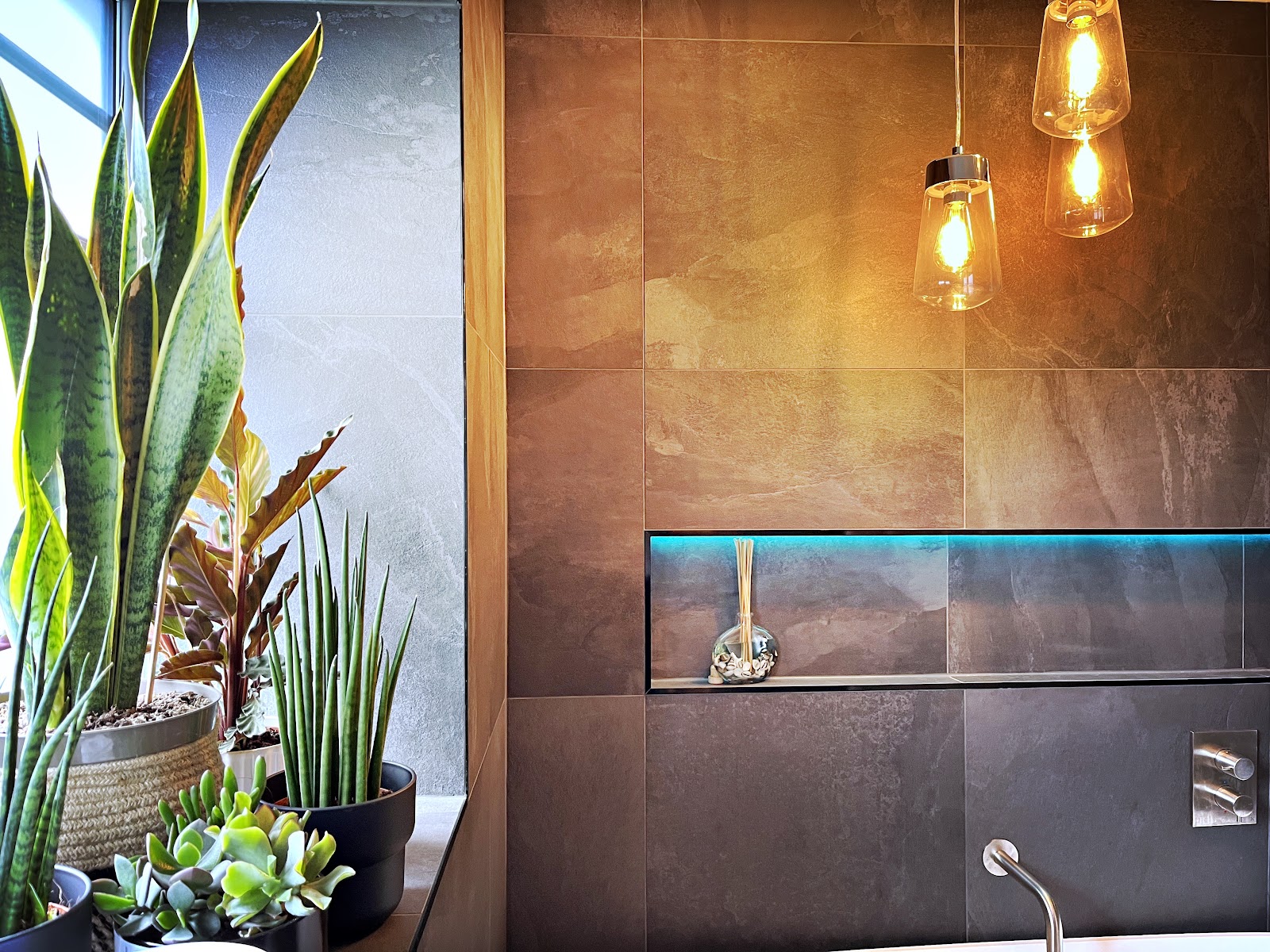 Bathroom with LED lit tile niche and glass pendant lights